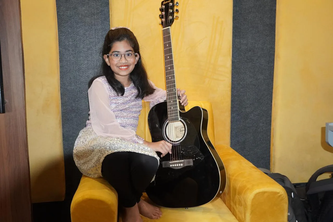 Young student with a guitar in the CloudStudio108 lounge